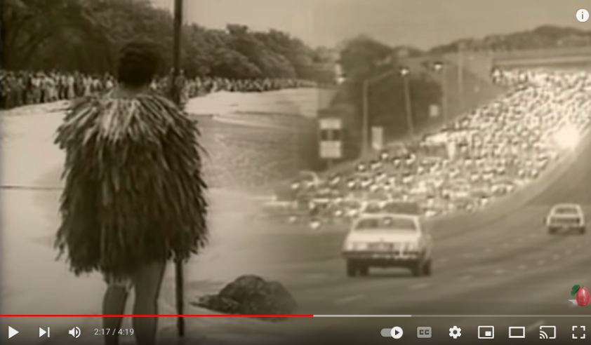 A native Hawaiian juxtaposed with traffic from the music video